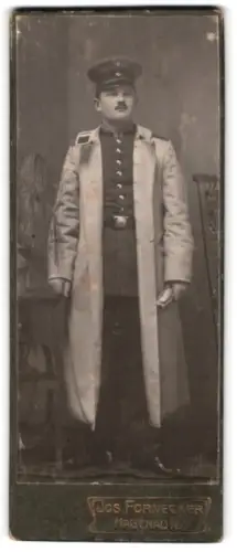 Fotografie Jos. Fornecker, Hagenau i. E., Unteroffizier in Uniform mit Mantel und Schirmmütze