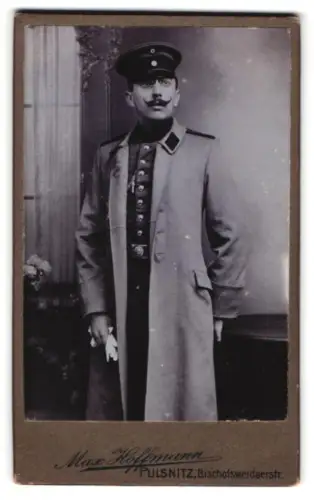 Fotografie Max Hoffmann, Pulsnitz, Bischofswerdaerstr., Soldat in Uniform mit Schützenschnur 1. Stufe im Mantel