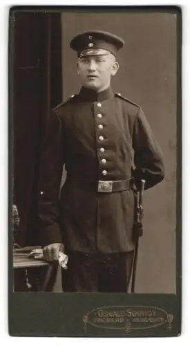 Fotografie Oswald Schmidt, Freiberg i. S., Weingasse 9, Soldat in Uniform mit Schirmmütze und Bajonett