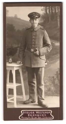 Fotografie Atelier Westerop, Bernburg, Neuestr. 19, Soldat in Feldgrau Uniform in Uniform mit Schirmmütze und Bajonett