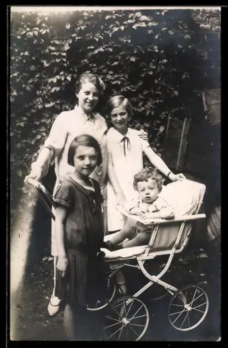 Foto-AK Junge Dame mit zwei Kindern u. Kleinkind im Kinderwagen, Garten, 1927