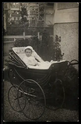 Foto-AK Kleinkind im Kinderwagen in einem Hof