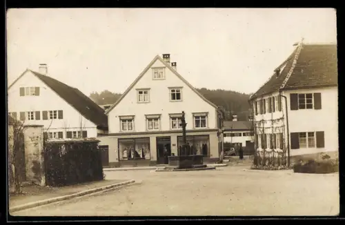Foto-AK Obergünzburg, Ortspartie mit Brunnen und Geschäft Cornet Hammel