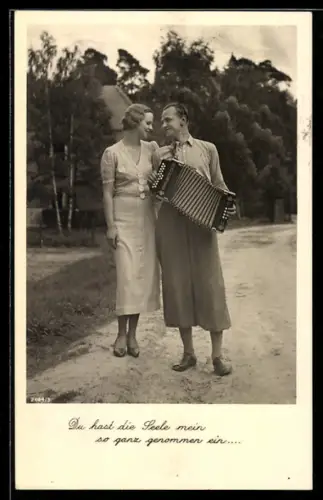 AK Hübsches Paar mit Akkordeon auf einer Strasse