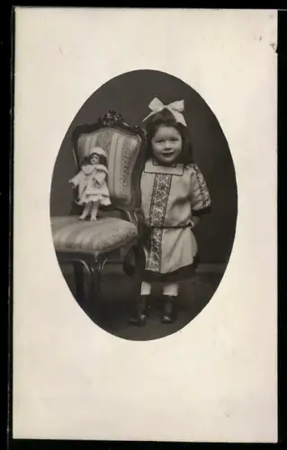 Foto-AK Kleines Mädchen neben Puppe auf einem Stuhl