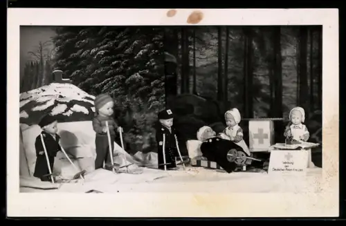 AK Puppen versorgen als Krankenschwestern einen Verletzten, Diorama, Werbung des Deutschen Roten Kreuzes