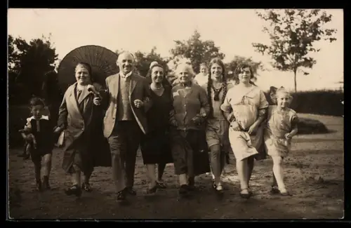 Foto-AK Familie beim Spaziergang, Junge hält eine Puppe im Arm