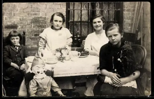 AK Mädchen hält an der Kaffeetafel seine Puppe im Arm