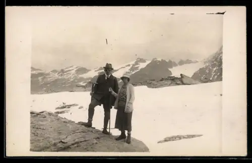 Foto-AK Paar beim Bergsteigen mit verschneitem Gebirgspanorama im Hintergrund
