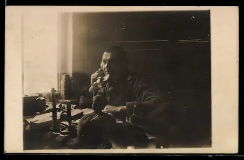 Foto-AK Soldat telefoniert an einem Tisch sitzend