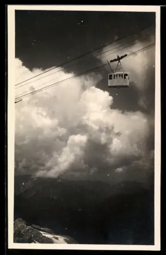 AK Garmisch-Partenkirchen, Seilbahngondel vor Wolkenhimmel