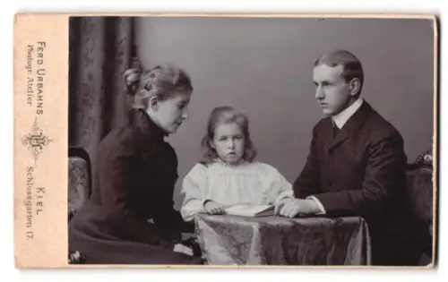 Fotografie Ferd. Urbahn, Kiel, Schlossgarten 17, Drei Personen sitzen an einem Tisch