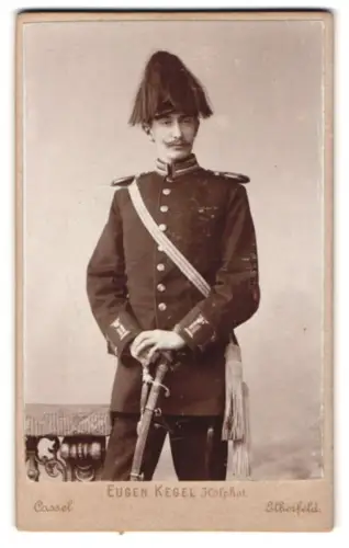 Fotografie Eugen Kegel, Elberfeld, Herzogstrasse 32, Garde-Offizier du Faur in Uniform mit Paradehelm, Schärpe und Säbel