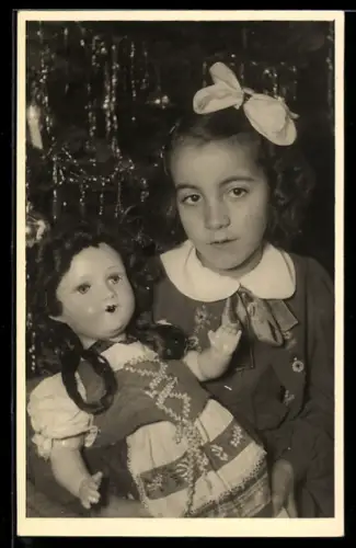 Foto-AK Mädchen mit Spielzeugpuppe vor Weihnachtsbaum