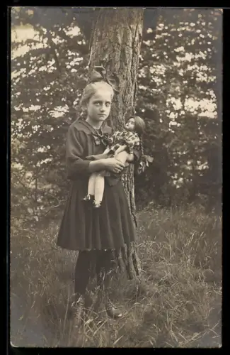 Foto-AK Mädchen mit ihrer Spielzeugpuppe auf einer Waldlichtung