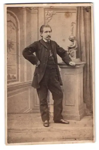 Fotografie unbekannter Fotograf und Ort, Mann in eleganter Pose neben Sockel