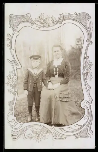 Foto-AK Frau und Junge in Matrosenkleidung in filigranem Passepartout