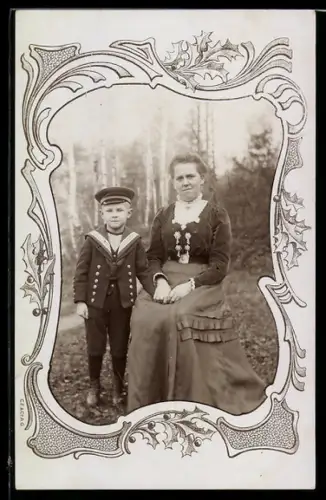 Foto-AK Dame und Kind mit Matrosenanzug in gemustertem Passepartout
