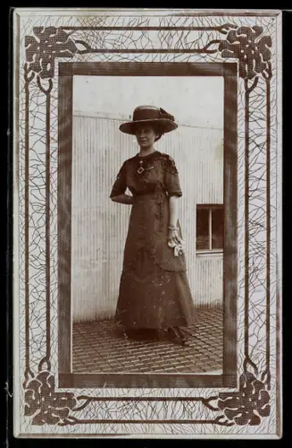 Foto-AK Elegante Dame in langem Kleid mit Hut, Passepartout mit Blättern