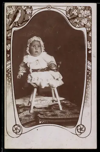 Foto-AK Kleinkind auf einem Stuhl sitzend, Passepartout mit Blumen