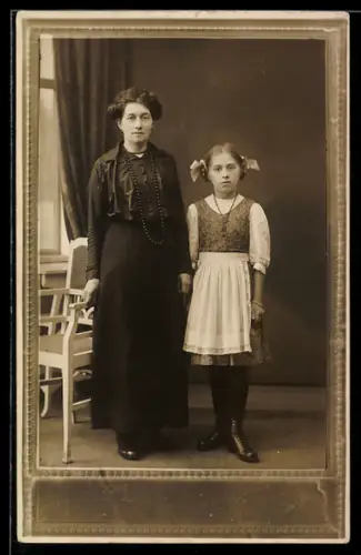 Foto-AK Mutter mit Tochter im Schürzenkleid, Ornament-Passepartout