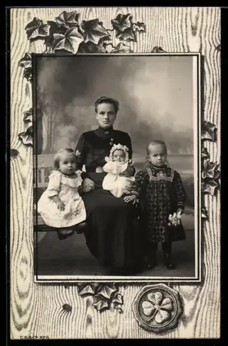 Foto-AK Junge Frau mit drei Kindern, Siegel mit Kleeblatt, Passepartout