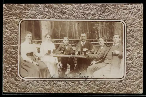 Foto-AK Familie sitzt bei Bier am Tisch, Passepartout