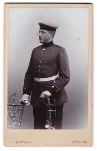 Fotografie H. J. Wittmak, Itzehoe, Paaschburg 52, Einjährig-Freiwilliger in Uniform mit Feldmütze und Säbel