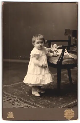 Fotografie Pieperhoff, Leipzig, Zeitzerstrasse 2, Kleines Kind mit Puppe neben einem Stuhl