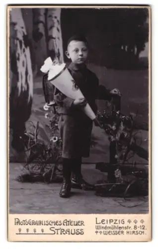 Fotografie Atelier Strauss, Leipzig, Windmühlenstr. 8-12, Junge mit Schultüte neben einem Zaun stehend