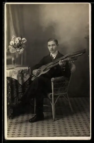 Foto-AK Mann mit einer Mehrhalsgitarre neben einer Blumenvase