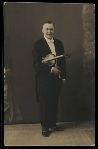 Foto-AK Lächelnder Geiger im Frack, Portrait mit Instrument
