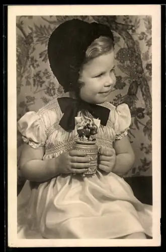 AK Kleines Mädchen mit schwarzer Kappe und Spielzeug in der Hand