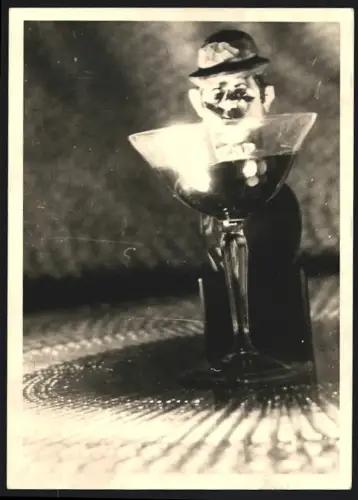 Fotografie Holzfigur mit Manneskopf und Melone hinter einem Glas