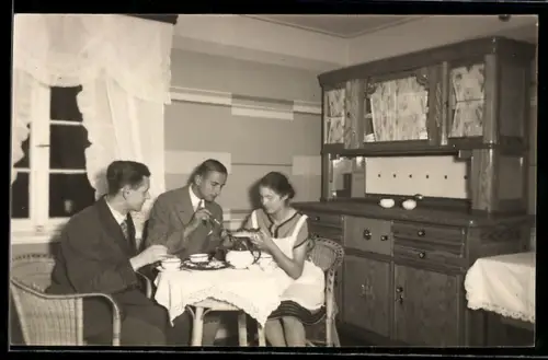 Foto-AK Zwei junge Männer und junge Frau beim Mittagessen 1929, Gastronomie