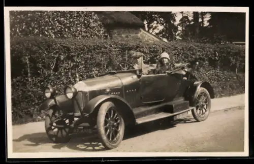 Foto-AK Auto mit Paar bei einer Ausfahrt auf einer Dorfstrasse