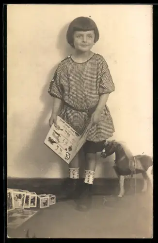 Foto-AK Kind mit Buch und Spielzeugpferd