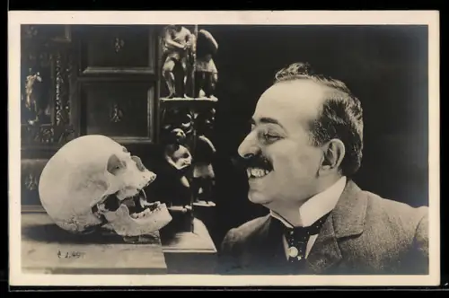 Foto-AK Lächelnder Mann steht vor einem Totenschädel