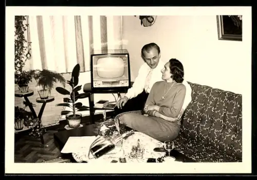 Foto-AK Paar auf einer Couch neben ihrem Fernseher