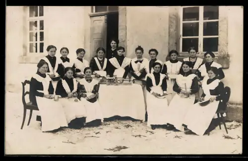 Foto-AK Gruppe von Dienstmädchen in Uniform vor einem Haus