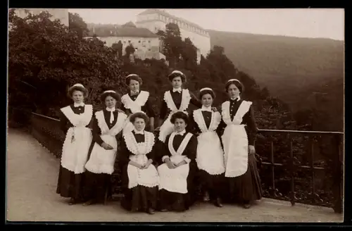 Foto-AK Gruppe von Dienstmädchen in Uniform vor einem Schloss mit Talblick