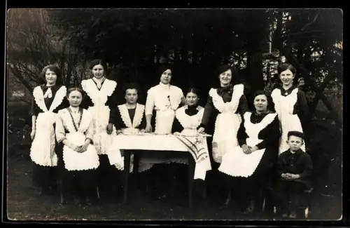 Foto-AK Gruppe von Dienstmädchen in Uniform an einem Tisch im Freien