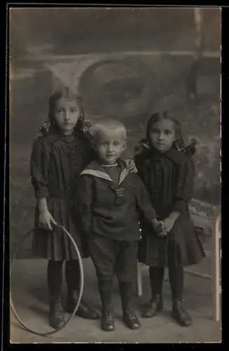 Foto-AK Drei Kinder mit einem Reifen