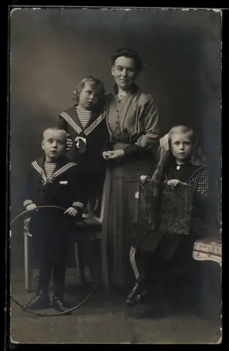 Foto-AK Frau und drei Kinder mit einem Reifen