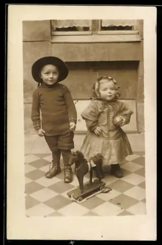 Foto-AK Kinderpaar mit Spielzeugpferd