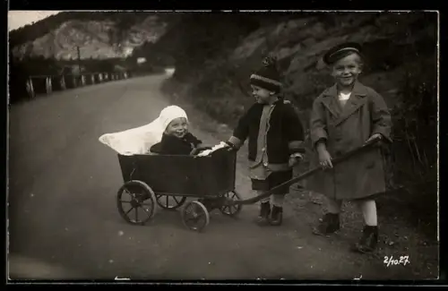 Foto-AK Drei Kinder mit einem Spielzeugwagen auf einer Strasse