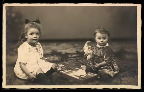 Foto-AK Zwei junge Kinder mit Spielzeughund