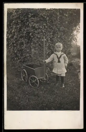 Foto-AK Kleiner Junge mit Spielzeugkarren