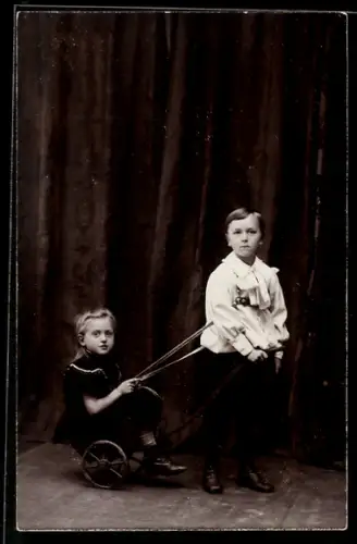 Foto-AK Kinderpaar mit einem Spielzeugwagen