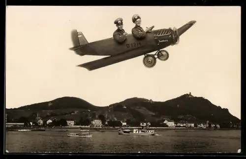 Foto-AK Zwei Soldaten des Heeres mit Flugzeug bei Flug über dem Rhein, Studiokulisse